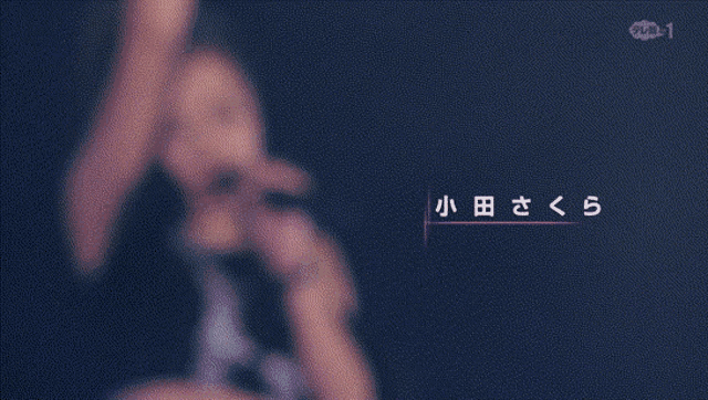 a woman is singing into a microphone with chinese writing on it