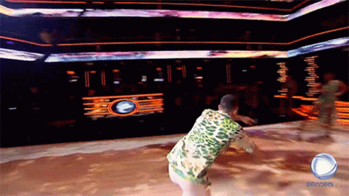 a man in a leopard print shirt is dancing on a stage with the word record on the bottom right