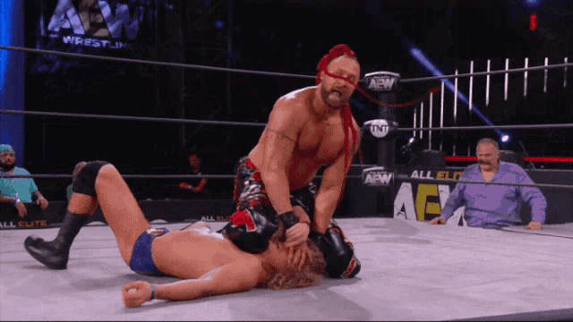 a wrestler is wrestling another wrestler in a ring that has aew on it
