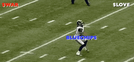 a football player is laying on his back on the field while another player runs towards the ball .