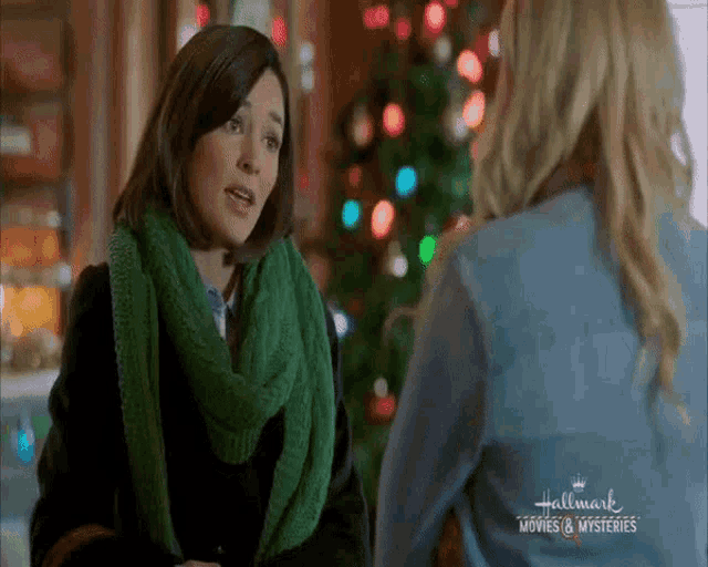 two women are standing next to each other in front of a christmas tree .