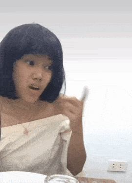 a woman with blue hair is sitting at a table with a plate