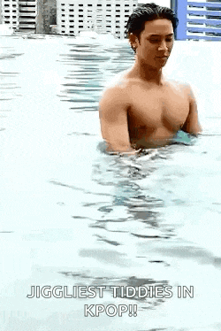 a shirtless man is standing in a swimming pool with the caption `` jiggliest tiddies in kpop '' .