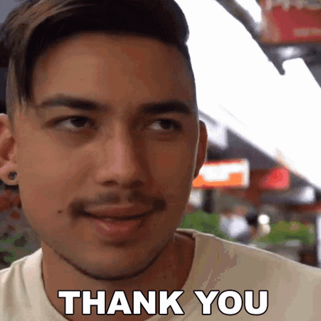 a man with a beard says thank you in front of his face