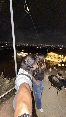 a man and a woman are standing on a balcony at night