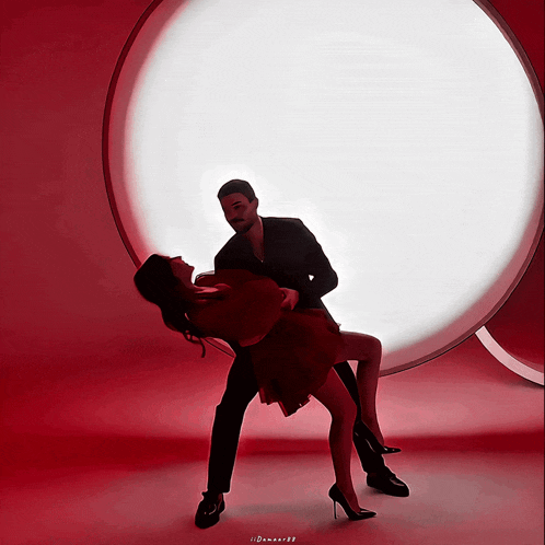 a man is holding a woman in his arms in front of a white circle with the name demon88 on the bottom