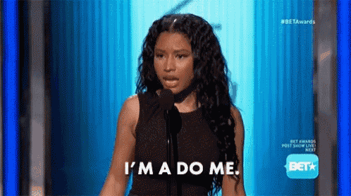 a woman is speaking into a microphone and saying `` i 'm a do me '' on a stage .