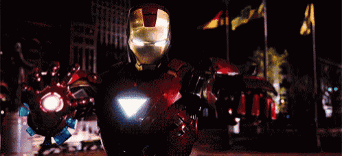 a close up of a man in a superhero costume with a red light coming out of his chest .