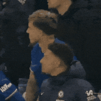 a group of men are sitting in a stadium watching a game .