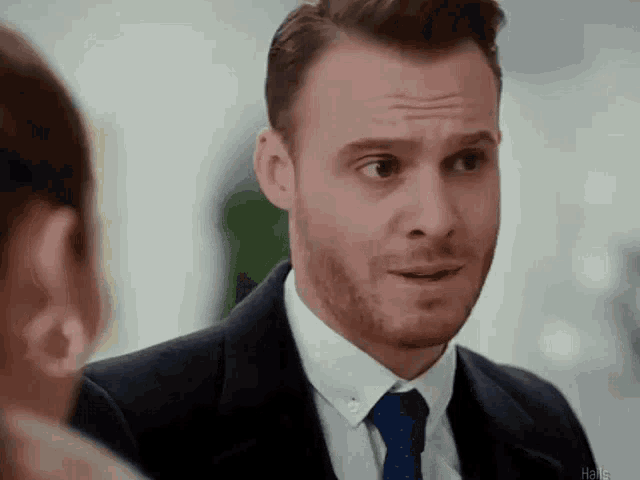 a man in a suit and tie is talking to a woman