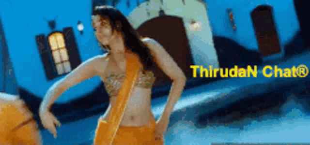 a woman in a yellow saree is dancing in front of a sign that says thirdan chatr