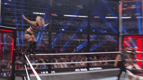 a female wrestler is doing a handstand in a ring