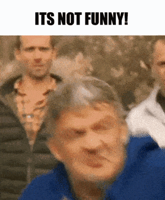 a man in a blue jacket is making a funny face while standing in front of a group of men .