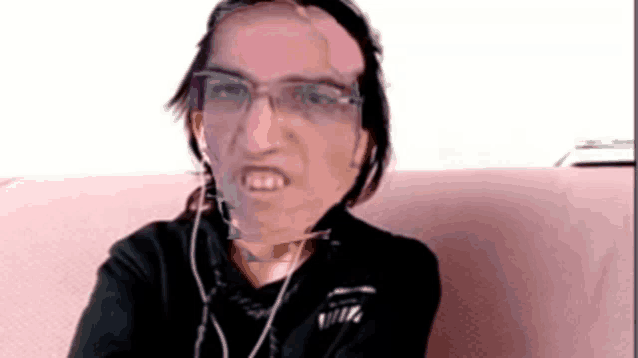 a woman wearing glasses and earbuds looks angry