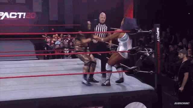 two women wrestling in a ring with a sign that says impact on it