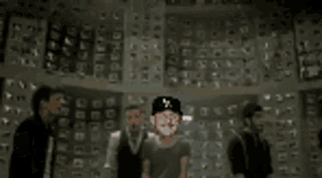 two men are standing next to each other and one of them is wearing a baseball cap with the letter t on it .