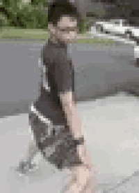 a young boy is kneeling down on a sidewalk .