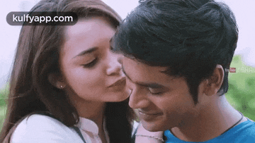 a woman is kissing a man on the cheek in a close up .