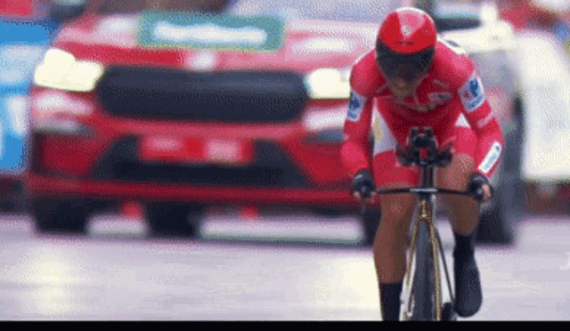 a man wearing a red helmet is riding a bike on a street