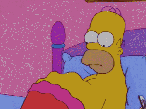 a cartoon of homer simpson laying in bed with a pink blanket