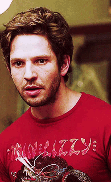 a man is wearing a red shirt that says nally on it