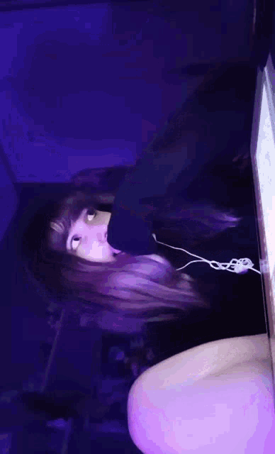 a girl wearing headphones is sitting in front of a laptop