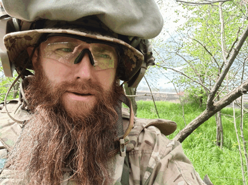 a man with a long beard wearing a helmet and sunglasses