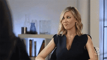 a woman in a blue dress is talking to another woman in a room .