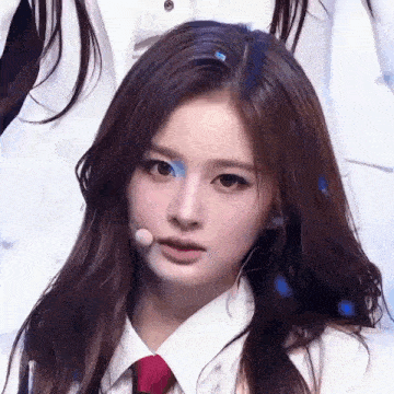 a close up of a girl wearing a white shirt and tie .