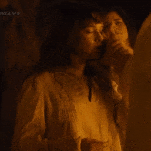 a woman in a white shirt is standing next to a man in a dark room with the word clips on the bottom right