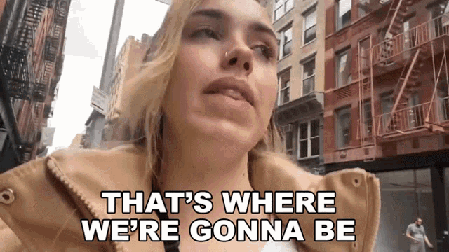 a woman says that 's where we 're gonna be in front of buildings