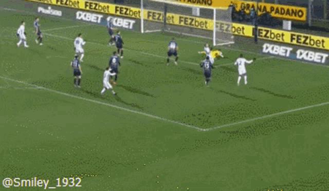a soccer game is being played on a field with advertisements for fezbet