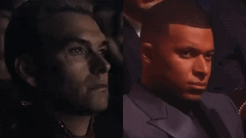 a man in a suit and tie is sitting next to another man