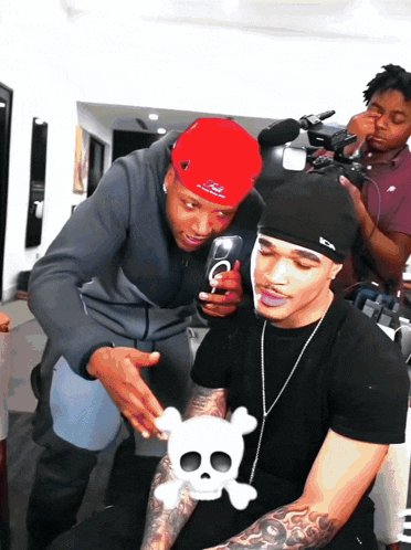 a man wearing a red hat with the letter o on it talks to another man
