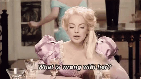 a woman in a purple dress is sitting at a table and asking what is wrong with her