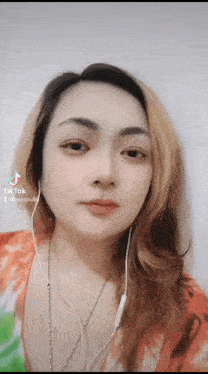 a close up of a woman wearing headphones and a tie dye shirt
