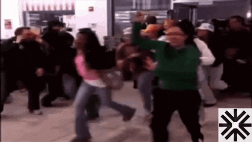 a group of people are dancing in a room with a snowflake in the corner