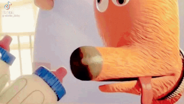 a close up of a stuffed animal holding a baby bottle