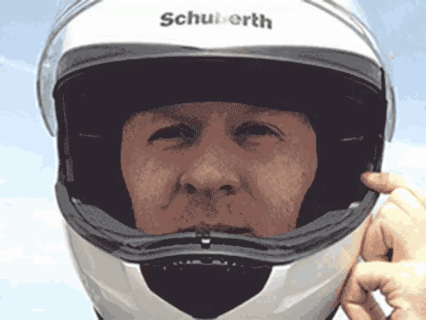 a man wearing a schuberth motorcycle helmet is adjusting it