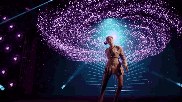 a woman in a white dress is standing in front of a purple and blue light