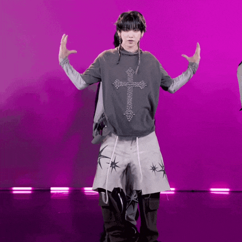 a person with a cross on their shirt is dancing