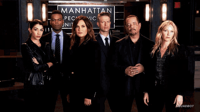 a group of people are posing in front of a sign that says manhattan
