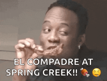 a man is eating a piece of chicken and says el compadre at spring creek