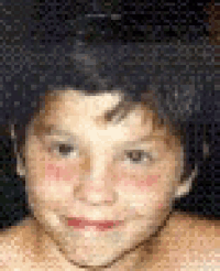 a close up of a young boy 's face with a polka dot background .