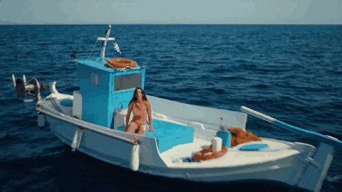 a woman sits on a boat in the ocean