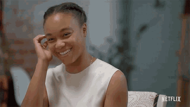 a woman in a white dress is smiling with a netflix logo in the corner