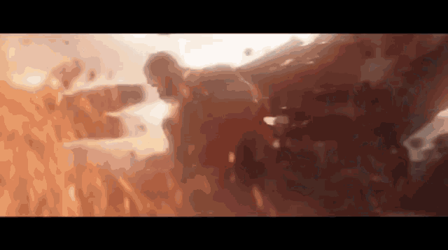 a blurred image of a man flying through the air in a field of fire .