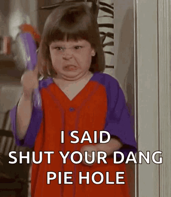 a little girl in a red and purple dress is holding a brush and saying i said shut your dang pie hole