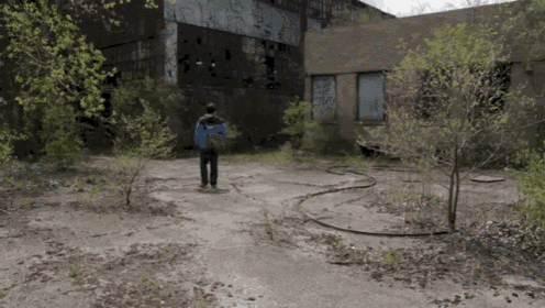 a man in a blue jacket stands in front of an old building