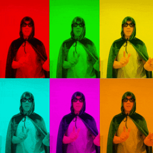 a man wearing a cape and sunglasses giving a peace sign